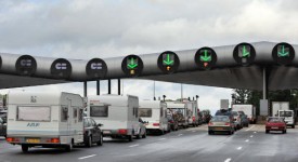 Vehicles queue in front of a highway tol